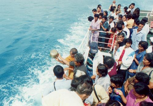 Blessing our safe passage.
A buddhist monk pours flower
petals over the waves.